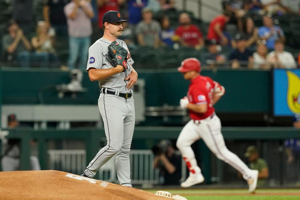 Detroit Tigers starting pitcher Tyler Alexander, left, walks by the mound after giving up a solo home run to Texas Rangers' Nathaniel Lowe rouding the bases during the first inning at Globe Life Field in in Arlington, Texas, on Friday, Aug. 26, 2022.
