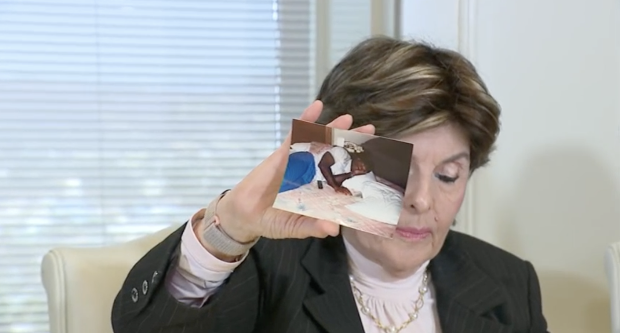 Attorney Gloria Allred holds up a photograph of Herschel Walker lying on a bed that her client alleges was taken in her hotel room.