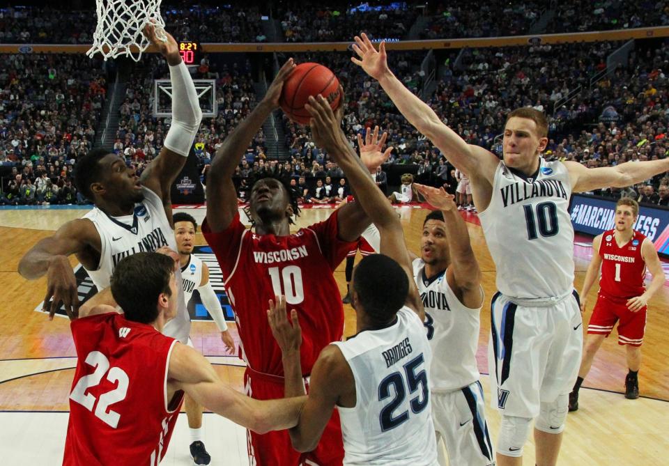 <p>Wisconsin forward Nigel Hayes (10) goes to the basket against Villanova forward Darryl Reynolds, left, guard Donte DiVincenzo (10) and Mikal Bridges (25) during the second half of a second-round men’s college basketball game in the NCAA Tournament, Saturday, March 18, 2017, in Buffalo, N.Y. Wisconsin won, 65-62. (AP Photo/Bill Wippert) </p>