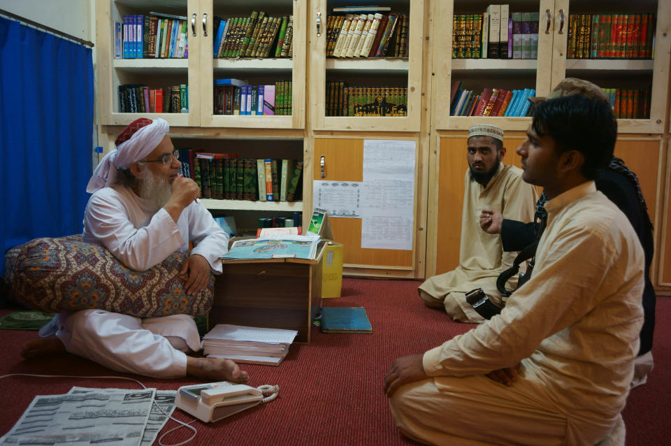 Maulana Abdul Aziz, left, head cleric of a Pakistani seminary, talks to visitor in a library named after slain al-Qaida leader Osama bin Laden, Friday, April 18, 2014 in Islamabad, Pakistan. A controversial Pakistani cleric who runs an Islamic seminary for girls in the capital of Islamabad has named the school's newly built library in honor of Osama bin Laden, his spokesman and a school administrator said. (AP Photo/B.K. Bangash)