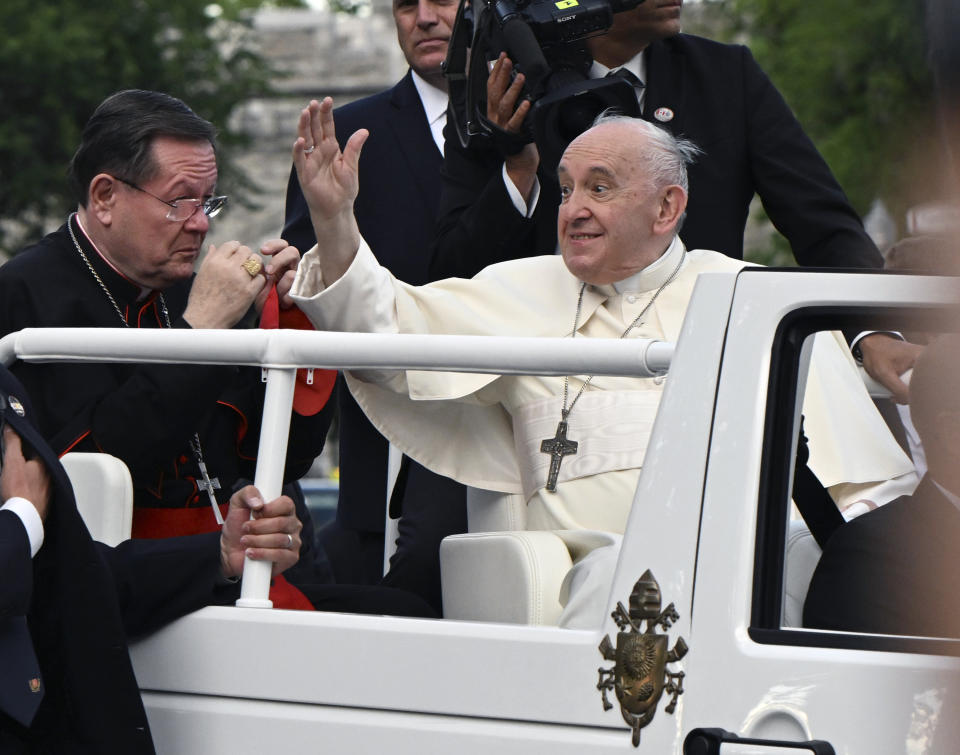 Pope Francis waves to the crowd, making his way to the Plaines of Abraham during his Papal visit across Canada in Quebec City, Wednesday, July 27, 2022. Cardinal Gerald Cyprien Lacroix is at the left. Pope Francis crisscrossed Canada this week delivering long overdue apologies to the country's Indigenous groups for the decades of abuses and cultural destruction they suffered at Catholic Church-run residential schools. (Nathan Denette/The Canadian Press via AP)