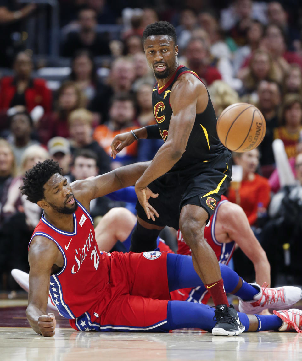 Cleveland Cavaliers' David Nwaba (12) and Philadelphia 76ers' Joel Embiid (21), from Cameroon, battle for the ball during the first half of an NBA basketball game Sunday, Dec. 16, 2018, in Cleveland. (AP Photo/Ron Schwane)