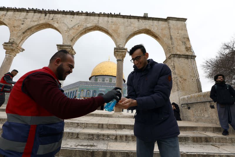 A visitor gets a cleaning gel for his hands in front of the Dome of the Rock in the compound known to Muslims as Noble Sanctuary and to Jews as Temple Mount, in Jerusalem's Old City