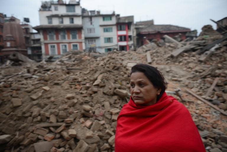 A Nepalese resident sits near buildings severely damaged by an earthquake in Kathmandu