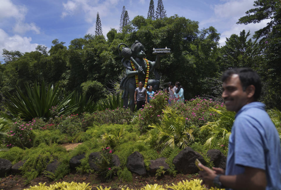 Visitors of the Kauai Hindu Monastery gather for a photo with Hanuman, the Hindu monkey deity renowned for his courage, power, and faithful selfless service to Lord Rama, on July 9, 2023, in Kapaa, Hawaii. In this sculpture, Hanuman carries the Iraivan Temple. (AP Photo/Jessie Wardarski)