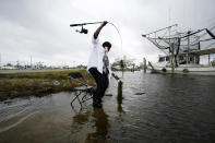 Minnie Lewis fishes for crabs before the wind and waves kick up, in Chalmette, La., Wednesday, Oct. 28, 2020. Hurricane Zeta is expected to make landfall this afternoon as a category 2 storm. (AP Photo/Gerald Herbert)