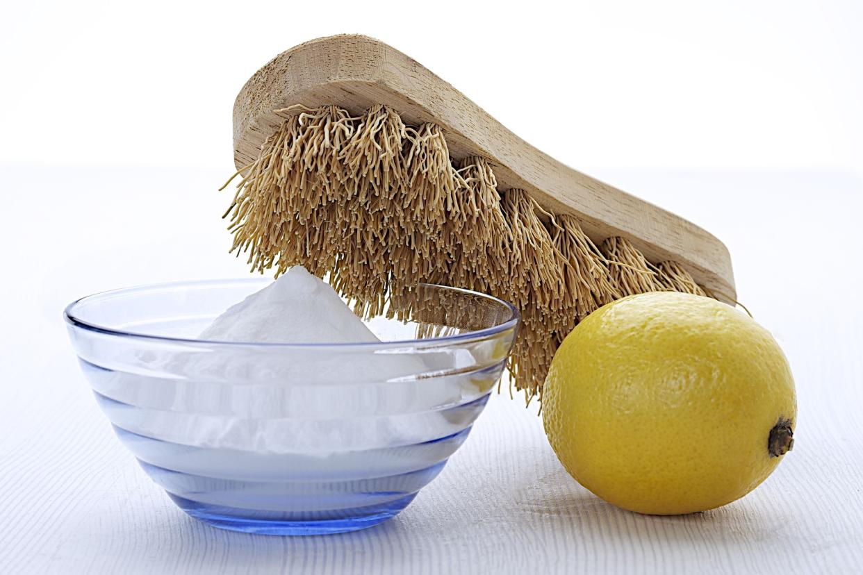 lemon, natural cleaning tool, and sodium bicarbonate in glass bowl