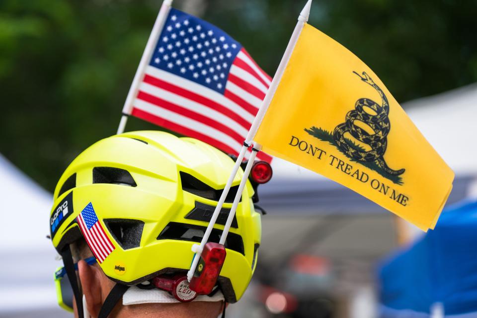 A man wears "Don't tread on me" flag, also known as a "Gadsden flag," mounted on his bicycle helmet in June. The man was among a group of Donald Trump's supporters who had gathered in Miami, where the former president was arraigned in federal court.