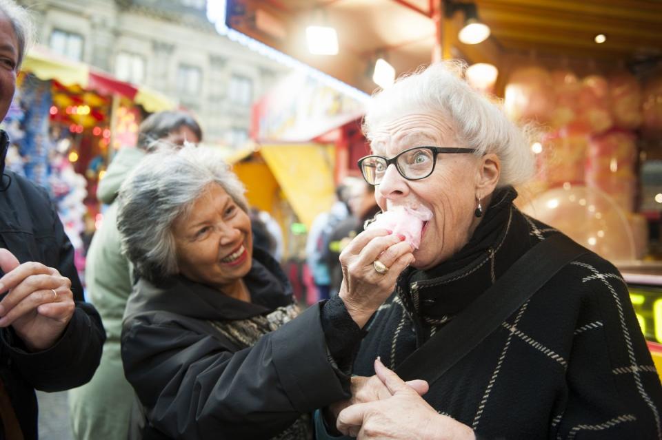 december holidays two women feeding each other cotton candy