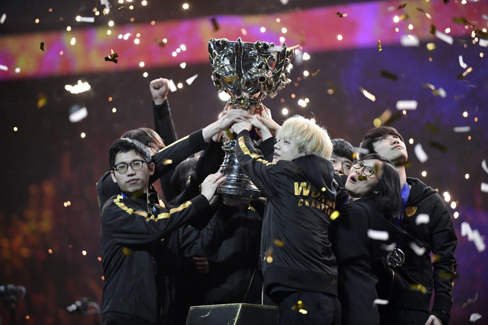 Team FunPlus Phoenix hold the trophy as they celebrate after winning the final of League of Legends tournament against Team G2 Esports, in Paris, Sunday, Nov. 10, 2019. The biggest e-sports event of the year saw a Chinese team, FunPlus Phoenix, crowned as world champions of the video game League of Legends. Thousands of fans packed a Paris arena for the event, which marked another step forward for the growing esports business. (AP Photo/Thibault Camus)