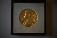 The 2021 Nobel Prize for Literature medal presented to Abdulrazak Gurnah, a Tanzanian-born novelist and emeritus professor who lives in the UK, is displayed before a ceremony to present to him at the Swedish Ambassador's Residence in London, Monday, Dec. 6, 2021. The 2021 Nobel Prize ceremonies are being reined in and scaled-down for the second year in a row due to the coronavirus pandemic, with the laureates receiving their Nobel Prize medals and diplomas in their home countries. (AP Photo/Matt Dunham)
