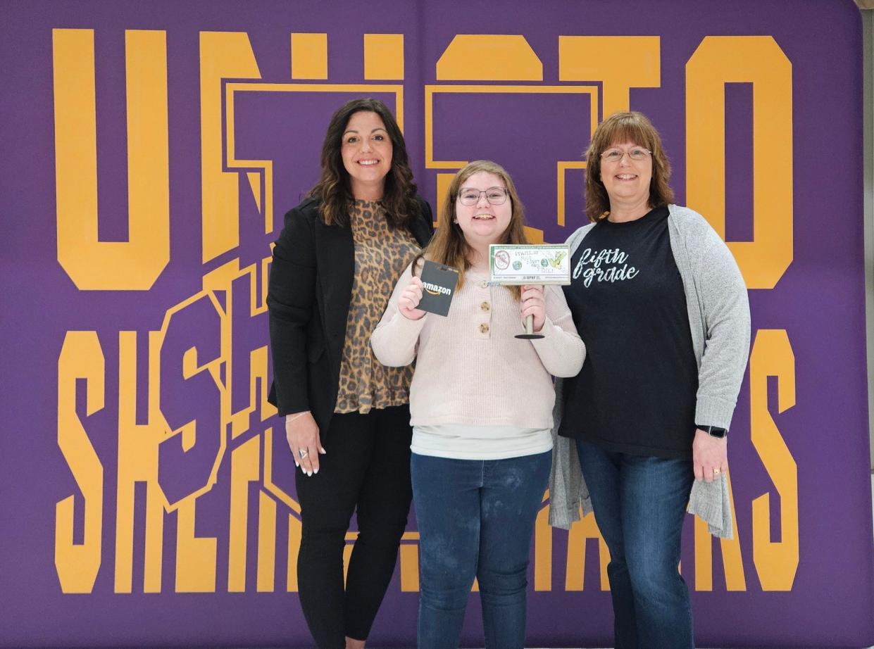 Aubrey Stirewalt, center, was shocked when teacher Davina Orr and Sarah Wood from Ross County Litter Control and Recycling told her she had won the billboard design contest.