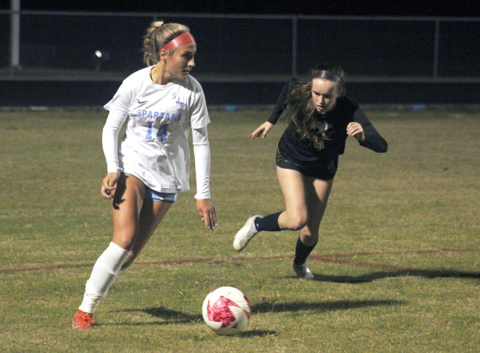 St. Johns Country Day midfielder Sydney Schmidt (14) dribbles as Atlantic Coast fullback Abbey Miller (3) defends during a December game.