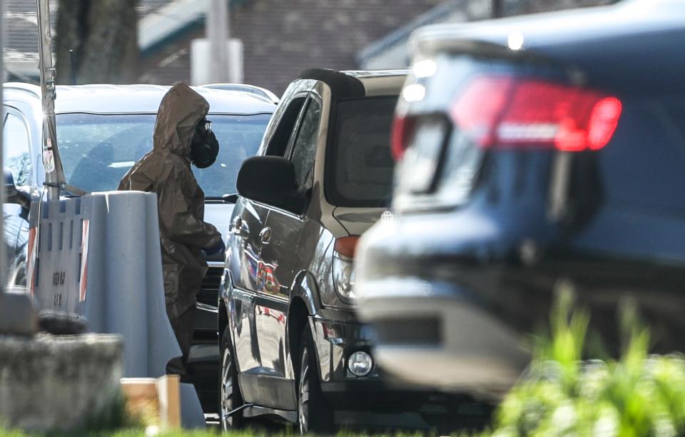 Individuals in hazard suits approach cars during COVID-19 testing on Wednesday, May 6, 2020, at Casa ALBA Melanie in Green Bay, Wis.