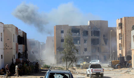 Smoke rises as fighters of Libyan forces allied with the U.N.-backed government gather at the eastern frontline of fighting with Islamic State militants, in Sirte, Libya, October 20, 2016. REUTERS/Ismail Zitouny