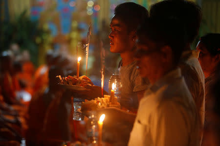 People hold offerings while praying for loved ones who have passed away during the first day of Pchum Ben festival, or the festival of the dead in Phnom Penh, Cambodia, September 25, 2018. REUTERS/Samrang Pring