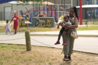 Tamika Davis, right, poses with three of her children, from left, Shanara, 3, Matthew, 11, and Lionel Jr., 2, at MLK Park in San Antonio, Thursday, May 30, 2024. Davis said friends and family watched her kids for most of her doctor visits during treatment last year for colon cancer. But she couldn't afford additional childcare, and she didn't know where to look for assistance. (AP Photo/Eric Gay)