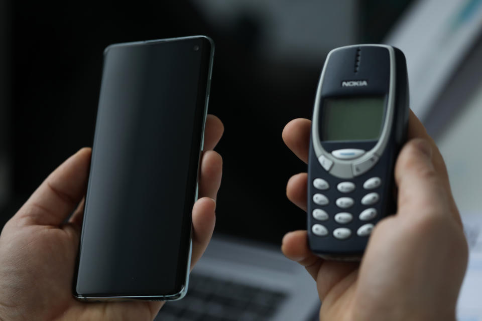 Minsk, Belarus - November 29, 2019: Male arm holding Samsung s 10 and Nokia 3310 cellphone