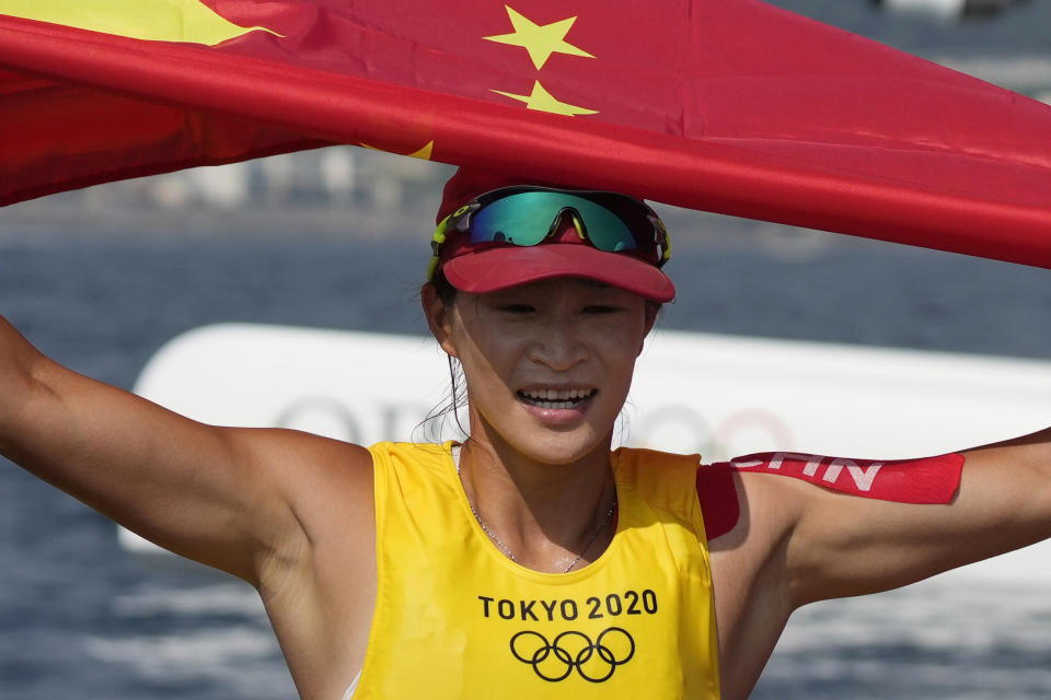 China's Lu Yunxiu celebrates after placing first during the women's windsurfer medal race at the 2020 Summer Olympics, Saturday, July 31, 2021, in Fujisawa, Japan. (AP Photo/Gregorio Borgia)