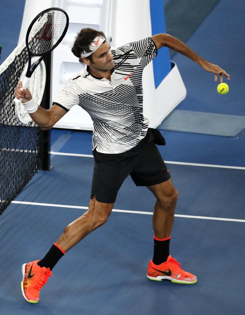 Switzerland's Roger Federer hits the ball into the stands as he celebrates his victory over Japan's Kei Nishikori at the Australian Open tennis championships in Melbourne, Australia, Sunday, Jan. 22, 2017. (AP Photo/Kin Cheung)