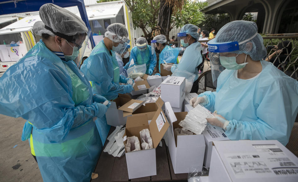 Health workers prepare equipments for nasal swab tests for workers in a local entertainment venue area where a new cluster of COVID-19 infections were found in Bangkok, Thailand, Thursday, April 8, 2021. Thailand has confirmed its first local cases of the coronavirus variant first detected in the U.K., raising the likelihood that it is facing a new wave of the pandemic, a senior doctor said Wednesday. (AP Photo/Sakchai Lalit)