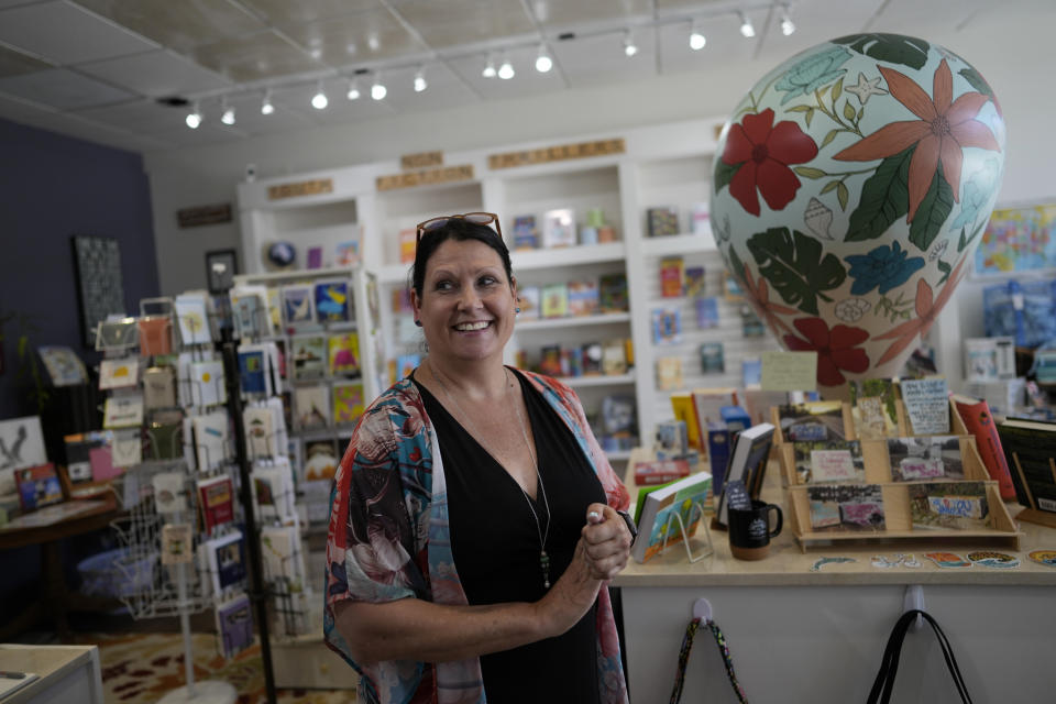 Owner Rebecca Binkowski walks inside the temporary location of MacIntosh Books and Paper, a store that has been a Sanibel Island fixture since 1960, in Fort Myers, Fla., Tuesday, May 2, 2023. Binkowski said her store had no flood insurance and lost about $100,000 worth of books and furnishings in the storm. "The fact of the matter is, we can get our businesses back up and running but without hotels to put people in, without our community moving back, it's going to be hard to do business," she said. "You hope this is still a strong community." (AP Photo/Rebecca Blackwell)