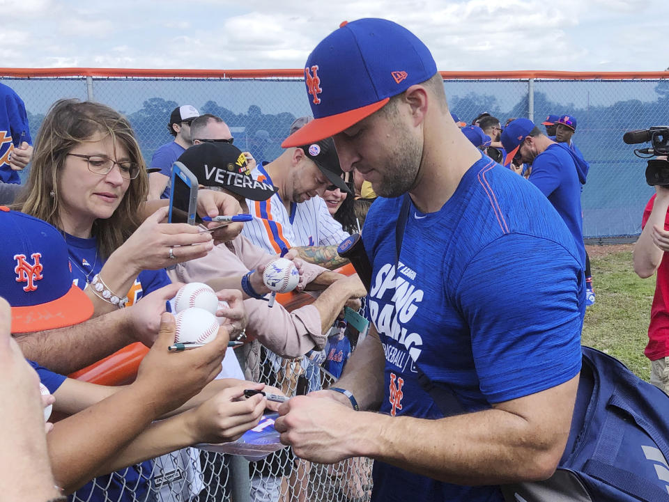 New York Mets’ Tim Tebow signs autographs at spring training baseball practice Saturday, Feb. 16, 2019, in Port St. Lucie, Fla. (AP Photo/Mike Fitzpatrick)