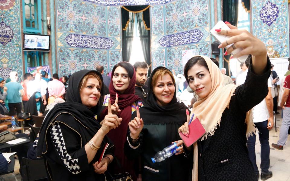 Iranian voters pose for 'selfie' photographs - Credit: EPA/ABEDIN TAHERKENAREH