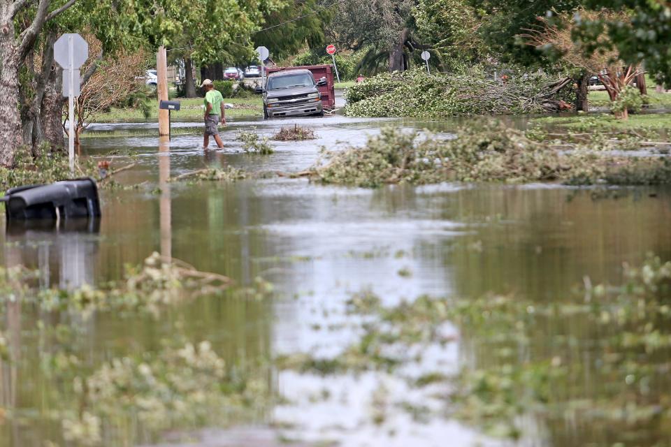 A man walks through the flooded streets in the Lakeview neighborhood of New Orleans in the aftermath of Hurricane Ida on Monday, August 30, 2021.