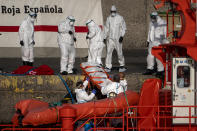 Emergency workers carry a migrant’s body after being found dead by the Spanish Maritime Rescue Service, at the Arguineguin port in Gran Canaria island, Spain, on Friday, Aug. 21, 2020. Spanish authorities say that five migrants have died and 11 survived while trying to reach the Canary Islands, bringing to 20 the number of people who have lost their lives that week in the perilous migration route to Europe. (AP Photo/Emilio Morenatti)