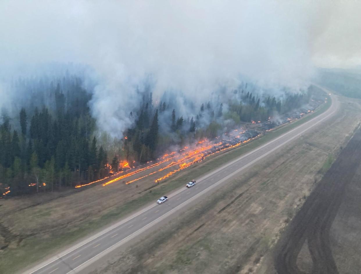 Fire crews are seen performing planned hand ignitions in forests near Fort Nelson, B.C., to limit the growth of the nearby Parker Lake wildfire on May 12. The fire continues to pose a threat to the town, but officials said residents could return early next week on Sunday. (B.C. Wildfire Service - image credit)