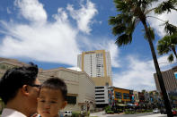 <p>A South Korean tourist carries his child in the Tumon tourist district on the island of Guam, a U.S. Pacific Territory, August 10, 2017. (Erik De Castro/Reuters) </p>