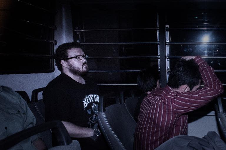 British banker Rurik Jutting (L), charged with the grisly murders of two women, sits in a prison van as he arrives at the eastern court in Hong Kong on November 24, 2014