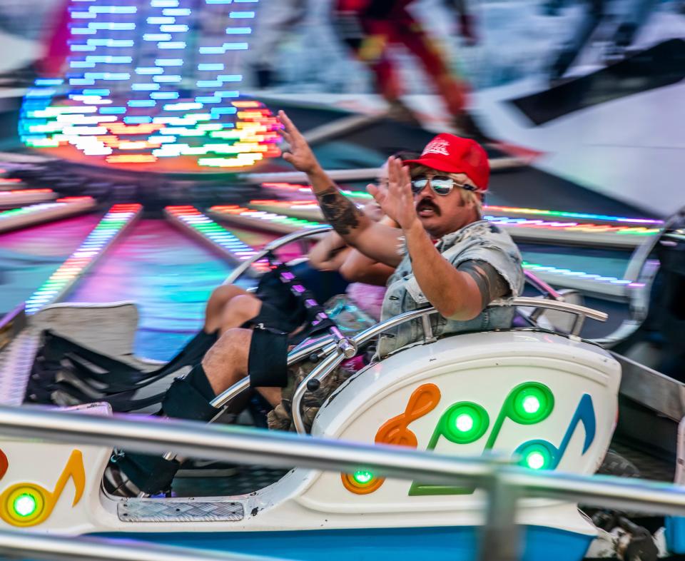 Roller coaster riders fly across the track during the first day of the combined Wilson County Fair and Tennessee State Fair in Lebanon Thursday, August 12, 2021.