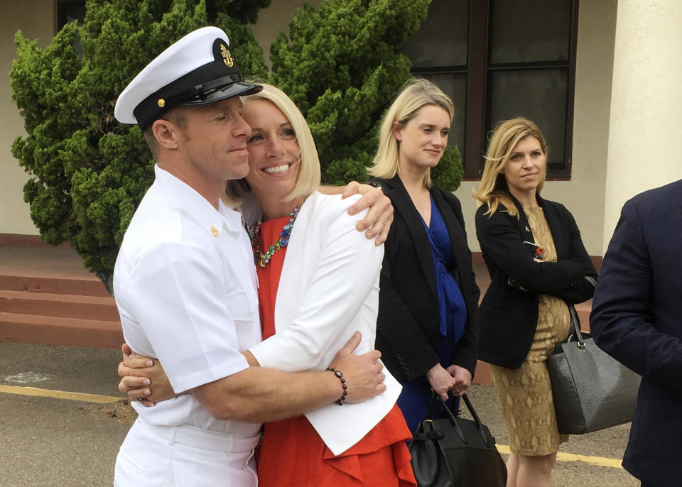 Navy Special Operations Chief Edward Gallagher, left, hugs his wife, Andrea Gallagher, after leaving a military courtroom on Naval Base San Diego, Thursday, May 30, 2019, in San Diego. The decorated Navy SEAL facing a murder trial in the death of an Islamic State prisoner was freed Thursday from custody after a military judge cited interference by prosecutors. (AP Photo/Julie Watson)