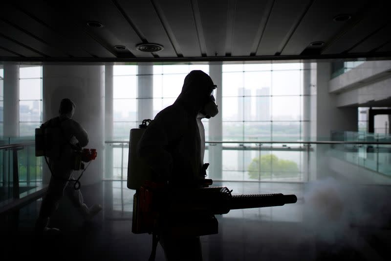 Volunteers from the Blue Sky Rescue team disinfect at the Qintai Grand Theatre in Wuhan