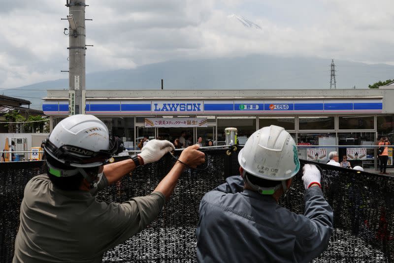 Workers erect a barrier to block the view of a popular Mount Fuji photo spot, in Fujikawaguchiko town