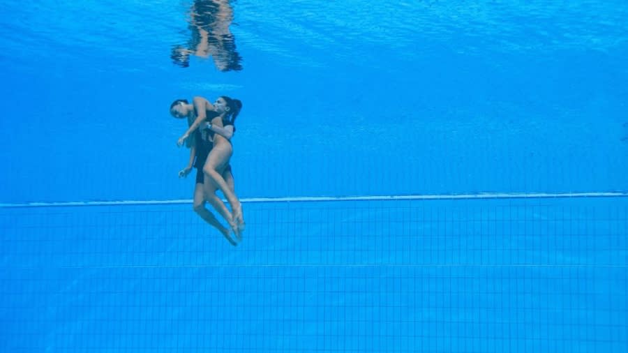 Anita Alvarez is retrieved from the pool by coach Andrea Fuentes during the 2022 FINA World Championships. (Oli Scarff/AFP via Getty Images)