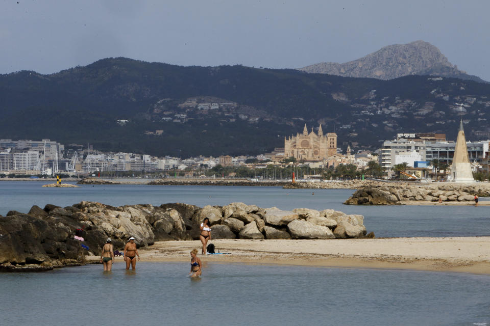 In this May 25, 2020 photo, people visit the beach in Palma de Mallorca, Spain. Spain's Balearic Islands will allow for thousands of German tourists to fly in from June 15 for a two-week trial of tourism under new regulations against the spread of the new coronavirus. (Isaac Buj/Europa Press via AP)