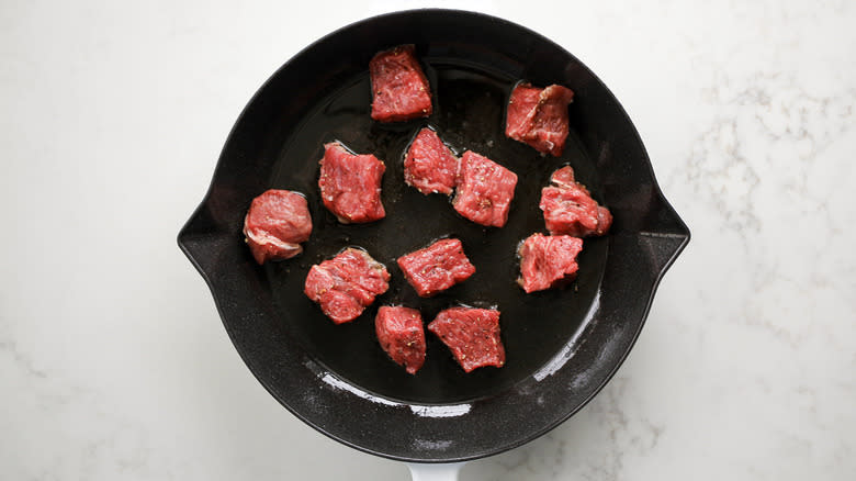 steak pieces in frying pan