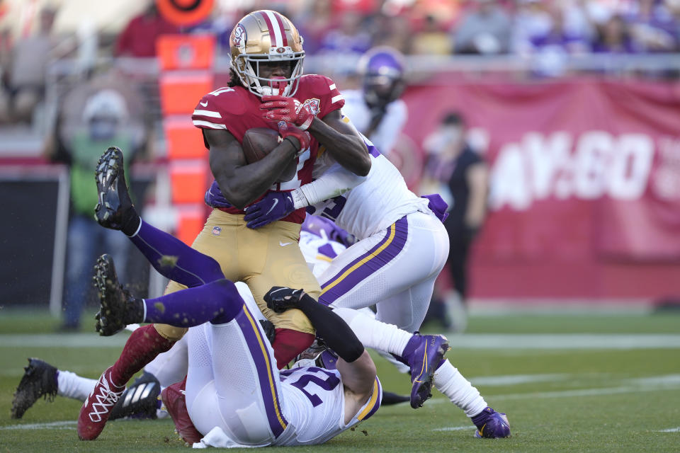 San Francisco 49ers wide receiver Brandon Aiyuk, top, is tackled by Minnesota Vikings safety Harrison Smith, bottom, and Minnesota Vikings free safety Xavier Woods during the first half of an NFL football game in Santa Clara, Calif., Sunday, Nov. 28, 2021. (AP Photo/Tony Avelar)