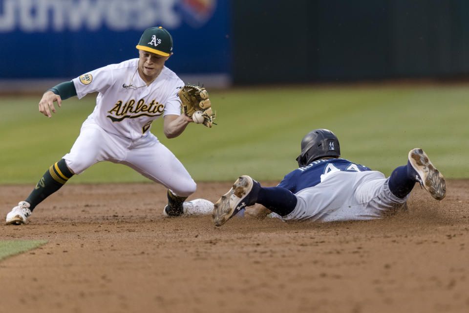 Seattle Mariners' Julio Rodriguez, right, steals second base as Oakland Athletics shortstop catches the throw Nick Allen during the third inning of a baseball game in Oakland, Calif., Wednesday, June 22, 2022. (AP Photo/John Hefti)