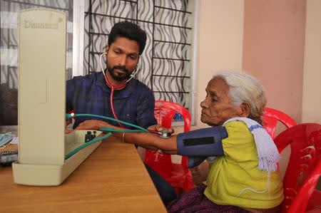 A doctor examines a flood-affected woman inside a relief camp in Chengannur in the southern Indian state of Kerala, India, August 20, 2018. REUTERS/Amit Dave