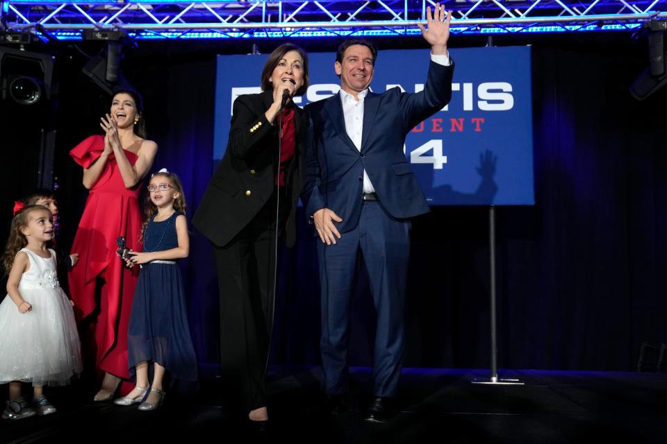 Republican presidential candidate Florida Gov. Ron DeSantis, right, waves to supporters as he stands with Iowa Gov. Kim Reynolds during a New Year's Eve campaign event, Sunday, Dec. 31, 2023, in West Des Moines, Iowa.