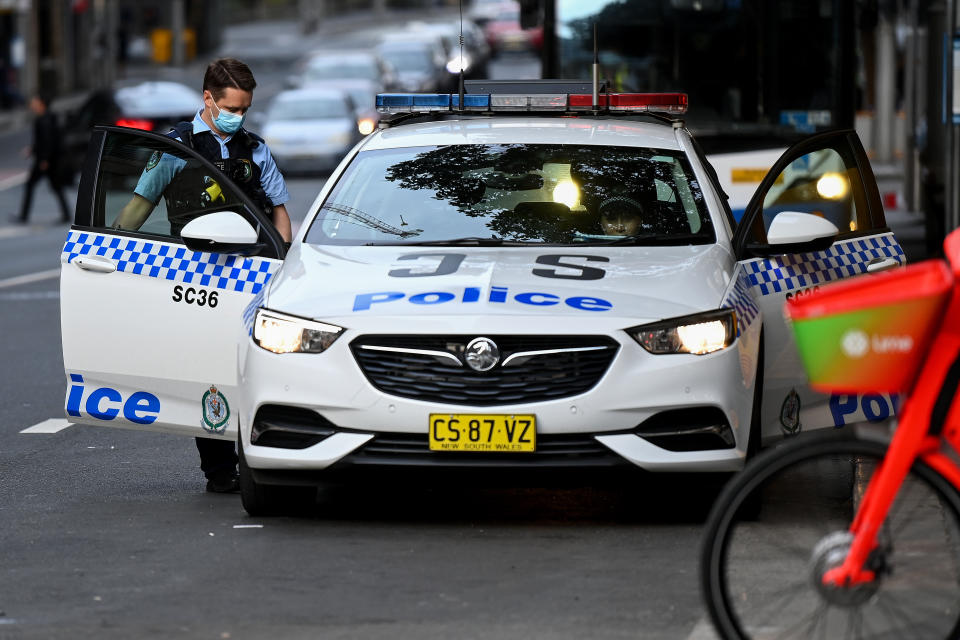 NSW Police officers seen wearing a face mask whilst getting into a patrol car in the CBD of Sydney, Thursday, July 8, 2021. NSW has recorded 38 new locally acquired COVID-19 cases overnight, the highest daily number of new cases in 14 months.