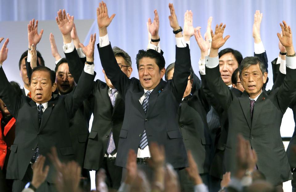 Japanese Prime Minister Shinzo Abe, center, shouts traditional "Banzai (long life)" cheers with lawmakers and members of his ruling Liberal Democratic (LDP) Party during its annual convention at a hotel in Tokyo, Sunday, March 5, 2017. Japan's ruling party approved a change in party rules Sunday that could pave the way for Prime Minister Shinzo Abe to become the country's longest-serving leader in the post-World War II era. (AP Photo/Shizuo Kambayashi)