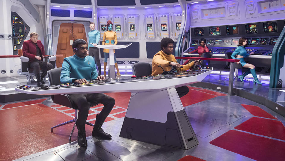 The crew of the USS Callister in 'Black Mirror' are shown inside their spaceship, each member attentively seated at their battlestations, focused on the view ahead from the ship's front.