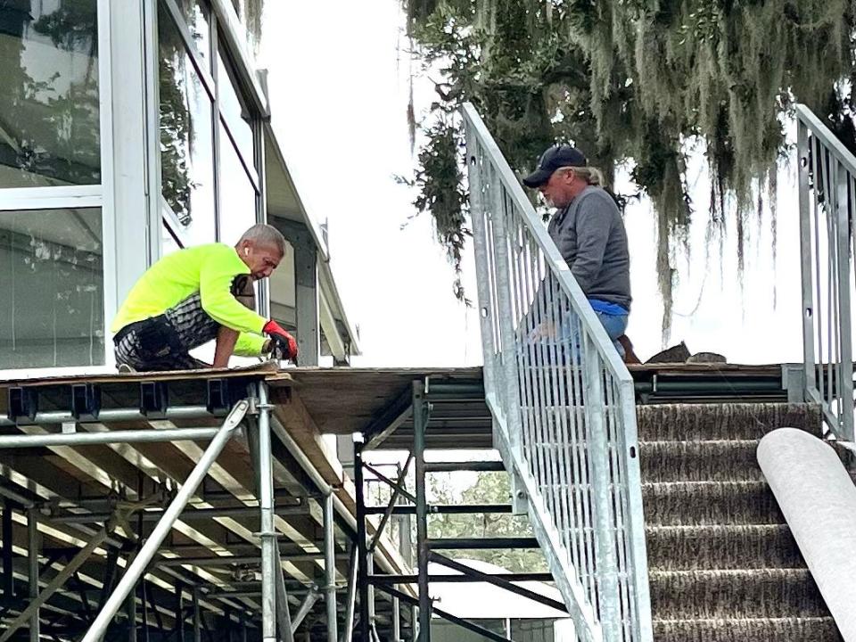 Workers finish laying carpeting at the hospitality venue surrounding the 18th green of the Timuquana Country Club on Friday in preparation for the Constellation Energy Furyk &amp; Friends tournament.