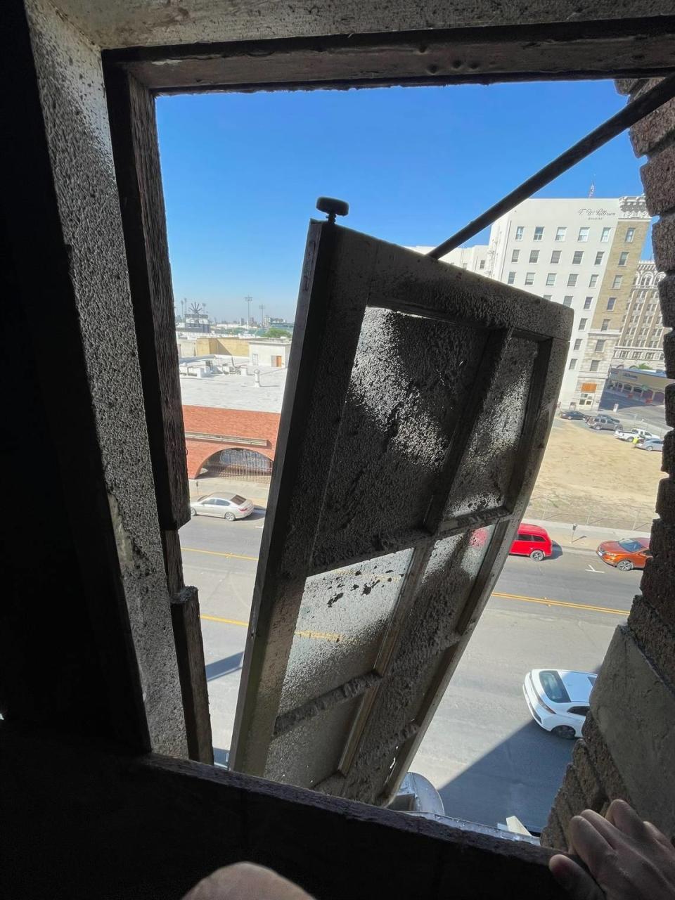 An upper-floor exterior window dangles from Hardy’s Theater above Van Ness Avenue in downtown Fresno, California. City officials identified the window as a safety hazard during an April 28, 2023, building inspection.