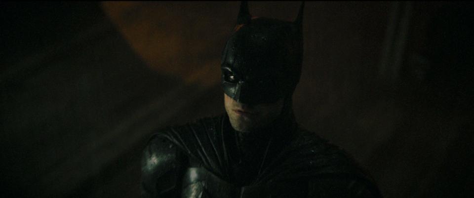 Robert Pattinson, bathed in shadow, as Batman in The Batman.